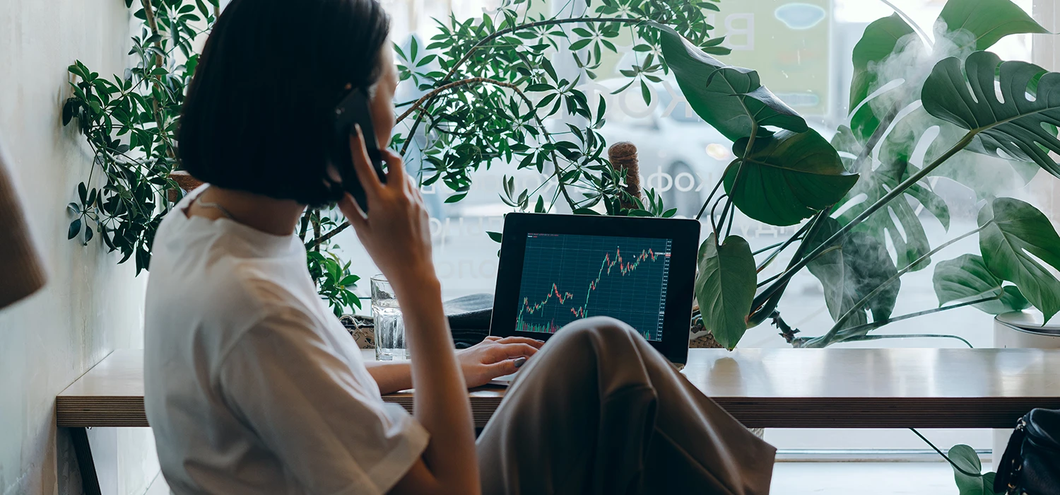 Personne qui regarde un écran avec une courbe du marché